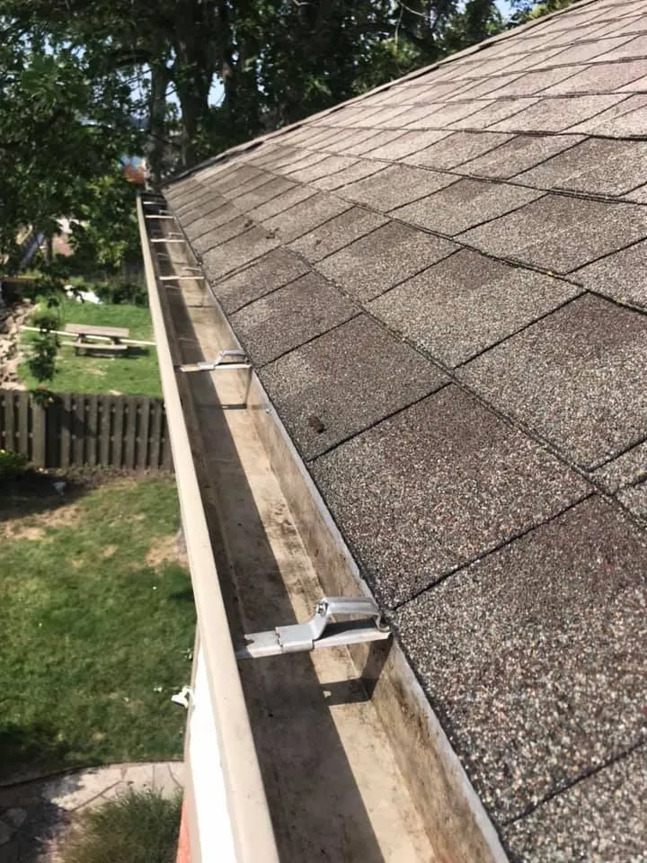 Cleaned gutter running along a shingle roof edge